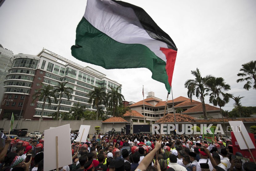 Para demonstran mengibarkan bendera Palestina di luar Kedutaan Besar AS di Kuala Lumpur, Malaysia, Jumat, (8 /12). Muslim Malaysia, termasuk anggota partai yang berkuasa, mengadakan demonstrasi di luar Kedutaan Besar AS mengenai tindakan kontroversial Washington untuk mengakui Yerusalem sebagai ibukota Israel .