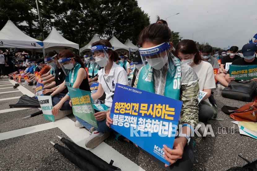  Para dokter memberikan penghormatan kepada para korban yang meninggal setelah terinfeksi virus corona dalam unjuk rasa menentang kebijakan medis pemerintah di Seoul, Korea Selatan, Jumat (14/8/ 2020). 
