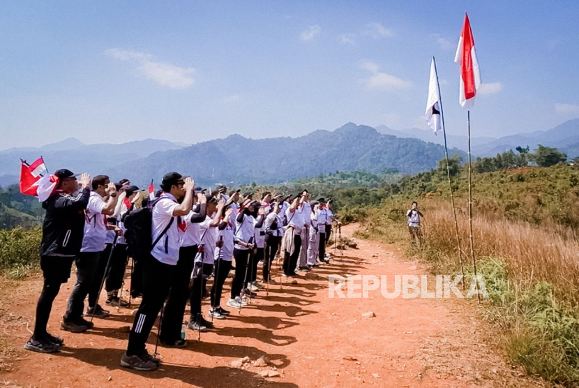 Para karyawan J99 Corp menggelar trekking atau berjalan kaki di alam terbuka dan mengibarkan bendera merah putih di puncak bukit Sentul, Bogor, Jawa Barat.