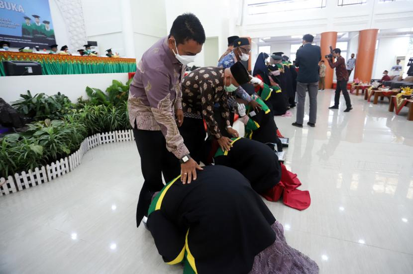 Para lulusan terbaik UIN Ar-Raniry Banda Aceh mencium kaki orang tua seusai menerima penghargaan dari rektor, Rabu (9/2).