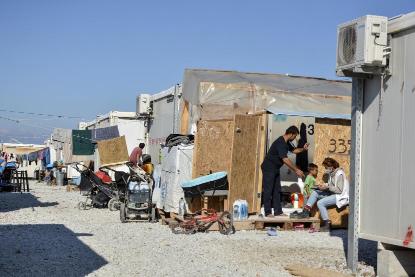 Para migran berkumpul di kamp pengungsi Karatepe, di pulau Lesbos, Aegean timur laut, Yunani
