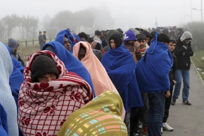 Para migran dari kamp Calais, Prancis mengantre untuk dipindahkan di hari ketiga evakuasi kamp tersebut, 26 Oktober 2016.