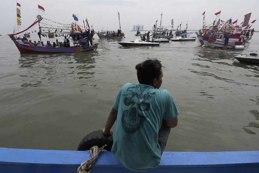 Para nelayan bersama keluarganya berlayar untuk mengikuti sedekah bumi Nadran di Muara Angke, Jakarta Utara, Minggu (13/12).