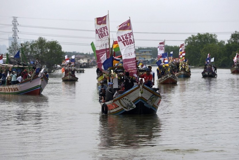 Para nelayan bersama keluarganya berlayar untuk mengikuti sedekah bumi Nadran di Muara Angke, Jakarta Utara, Minggu (13/12). 