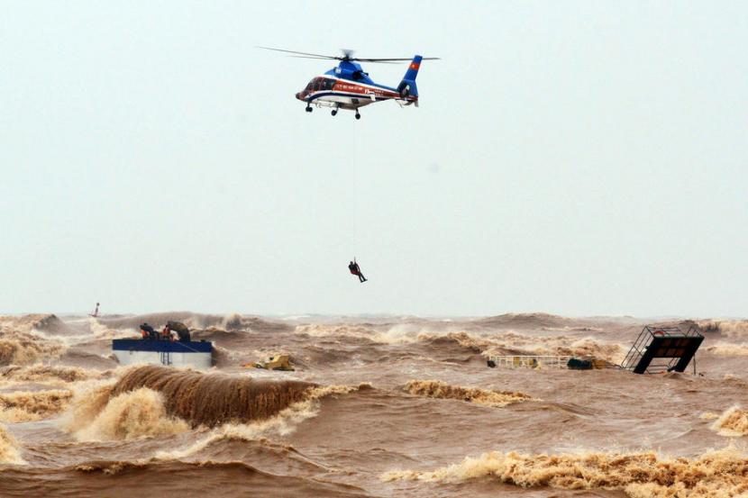 Para nelayan diselamatkan oleh penjaga pantai dan helikopter saat angin kencang menghantam pantai Vietnam tengah di provinsi tengah Quang Tri, Ahad (11/10).