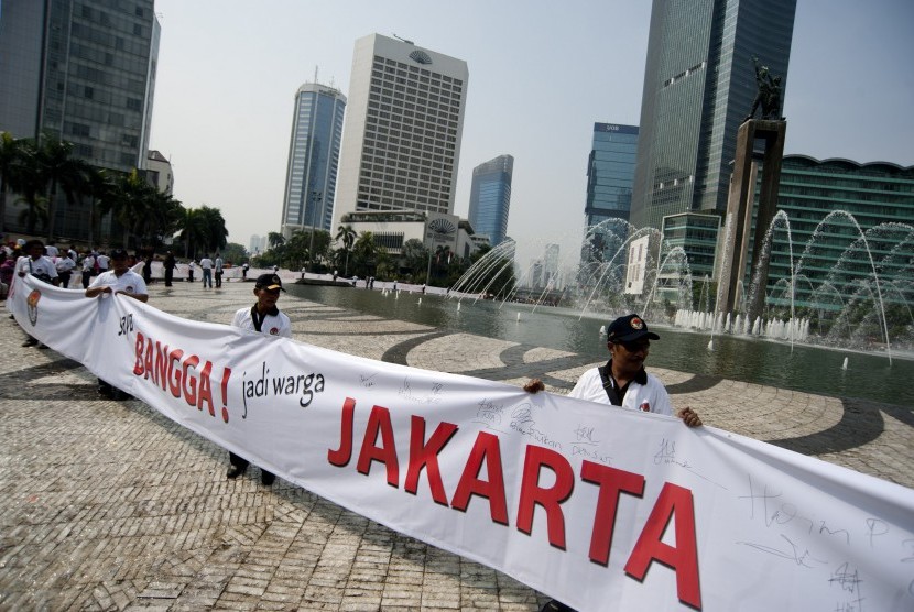 Para panitia pengawas lapangan (PPL) Panwaslu memegang spanduk Bangga Jakarta dalam aksi simpati Panwaslu untuk DKI Jakarta Pemilu Damai di Bundaran HI, Jakarta, Ahad (7/10). 
