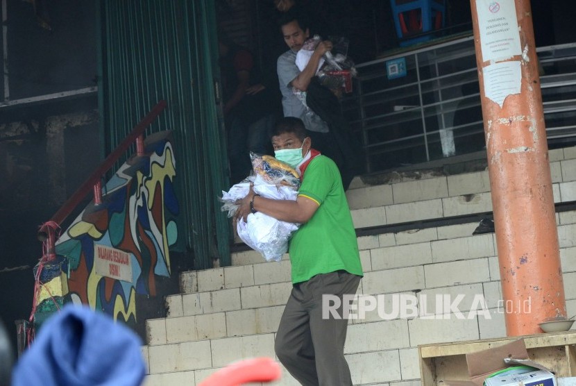 Para pedagang berusaha menyelamatkan barang-barangnya saat peristiwa kebakaran di Pasar Kosambi, Kota Bandung, Ahad (19/5).