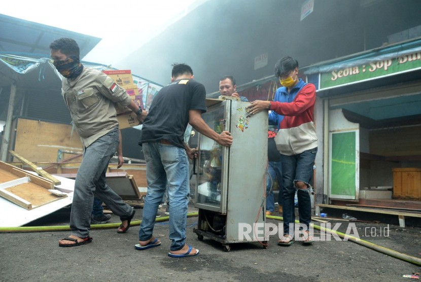 Para pedagang berusaha menyelamatkan barang-barangnya saat peristiwa kebakaran di Pasar Kosambi, Kota Bandung, Ahad (19/5). 