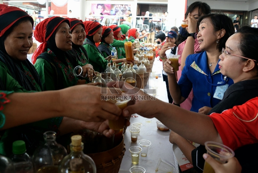 Para pedagang jamu melayani konsumen saat acara Makan bakso dan minum jamu bersama dalam peringatan Hari Konsumen Nasional di Lapangan Parkir Gedung Sarinah, Jakarta, Ahad (10/5).  (Republika/Prayogi)