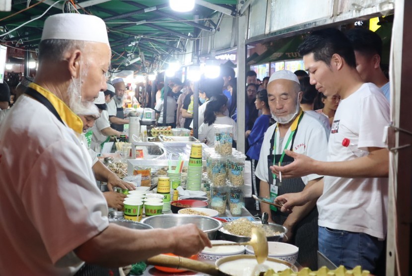 Para pedagang makanan halal di pasar malam melayani pembeli di Kota Lanzhou, Provinsi Gansu, Cina, Jumat (6/7). Provinsi Gansu yang dihuni sekitar 3,4 persen umat Islam dari total populasi 27 juta jiwa itu merupakan salah satu penghasil makanan halal terbesar di Cina yang sudah merambah 40 negara lainnya. 