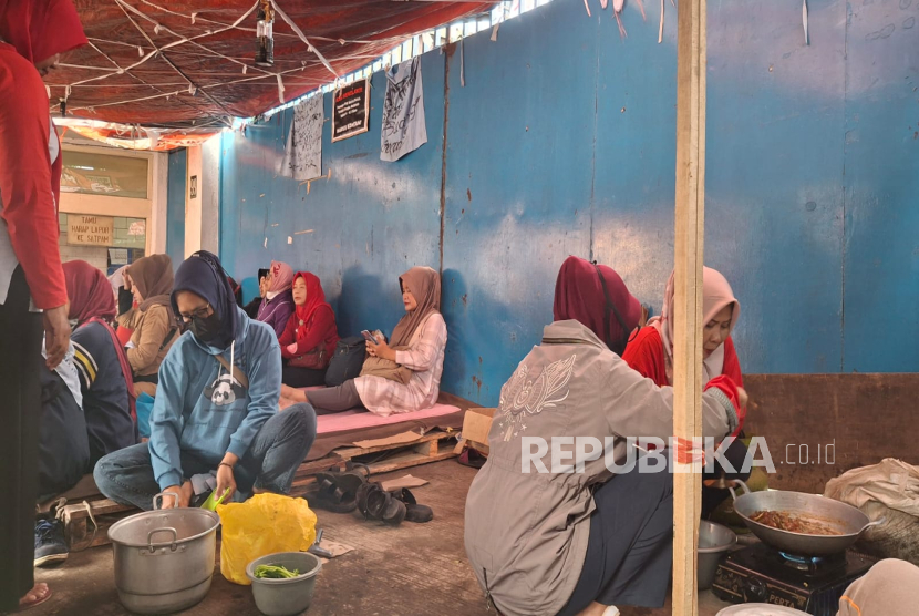 Para Pekerja atau Buruh yang Terdampak PHK Berada di Tenda yang Didirikan Depan Perusahaan di Kota Cimahi, Jawa Barat. Mereka Melakukan Aksi untuk Menuntun Pesangon Dibayarkan Sekaligus.