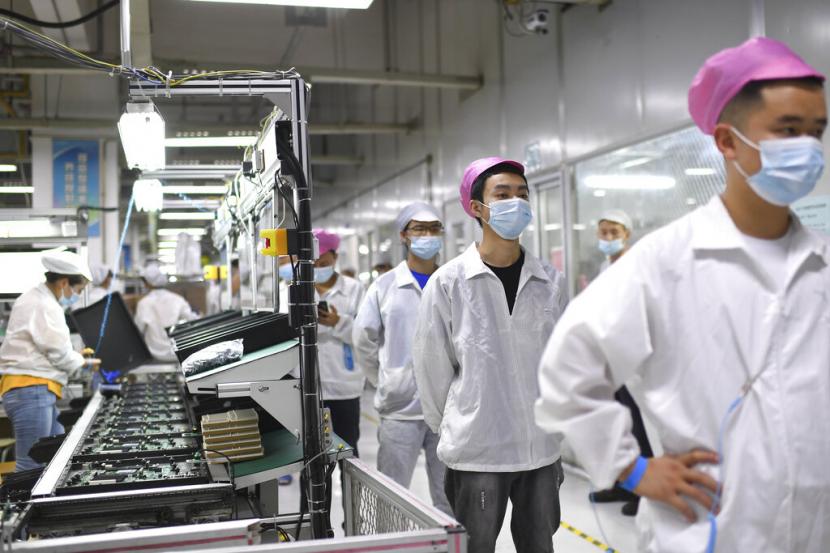 Para pekerja berbaris untuk menjalani tes COVID-19 di pabrik Foxconn di Wuhan di provinsi Hubei, China tengah pada 5 Agustus 2021.