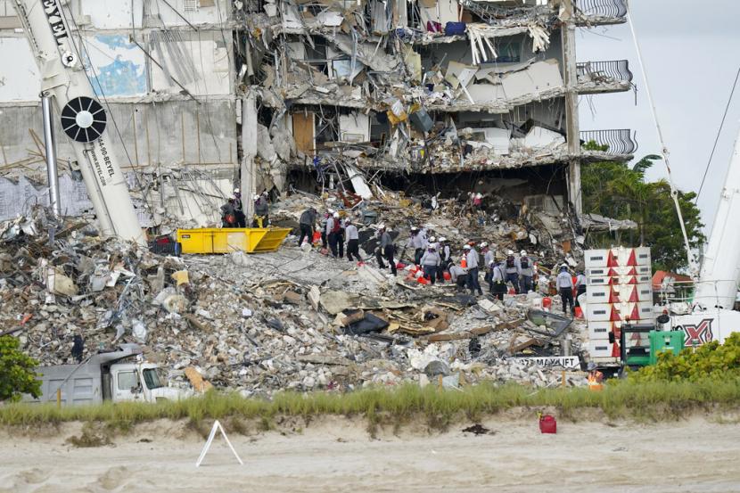Para pekerja di reruntuhan kondominium Champlain Towers South, Surfside, Florida, Amerika. Penghentian operasi pencarian jenazah korban di reruntuhan gedung kondominium yang roboh pada 24 Juni lalu sudah diputuskan.
