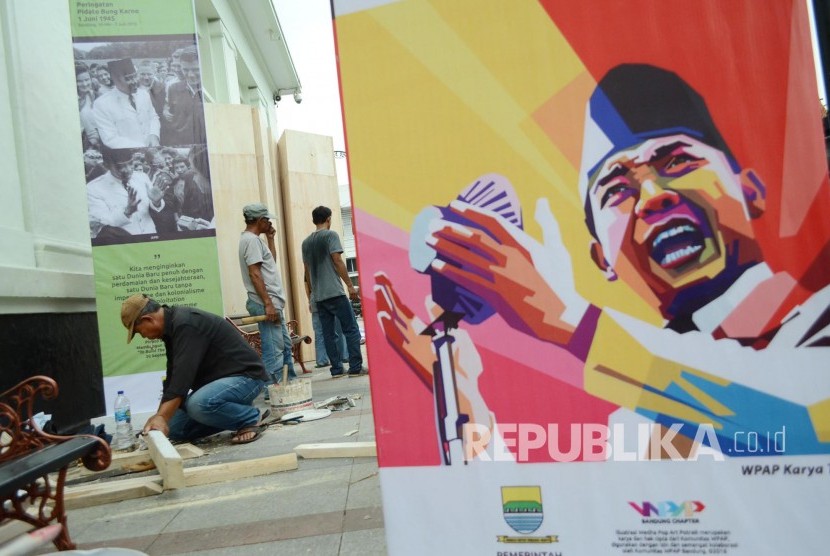 Para pekerja memasang gambar-gambar Presiden pertama RI Sukarno.