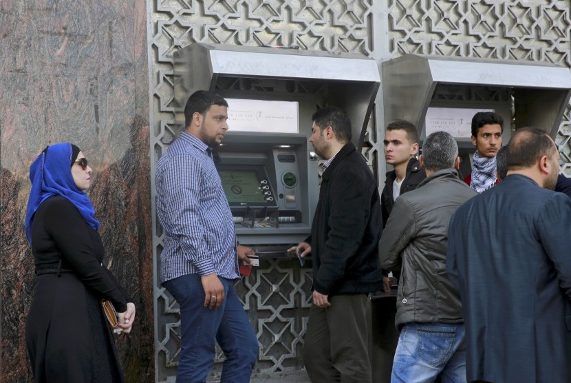 Para pekerja mengantre di dekat ATM di Kota Gaza, Rabu (5/4) untuk menarik gaji bulanan mereka. Sebanyak 132 ribu pegawai Otoritas Palestina akan mengalami pemotongan gaji. Ilustrasi.