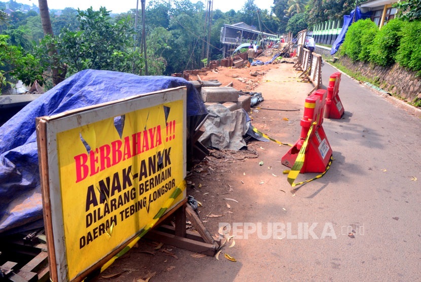 Para pekerja mengerjakan perbaikan jalan yang longsor di Jalan Jagakarsa, Jakarta, Selasa (5/4).  (foto : MgROL_45)
