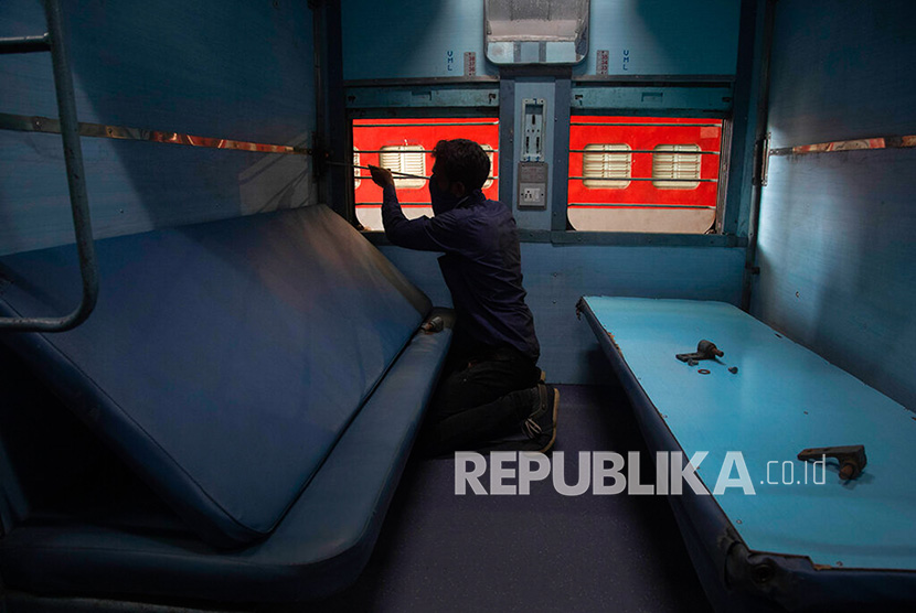  Para pekerja mengubah gerbong kereta api menjadi ruang isolasi untuk pasien corona atau covid-19 di Gauhati, India, Ahad (29/3). 