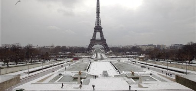 Para pekerja tengan membersihkan salju menggunakan kendaraan khusus pembersih salju di sekitar Menara Eiffel, Paris, Prancis, Ahad (5/2). Cuaca ekstrim dan beku melanda sejumlah negara Eropa.