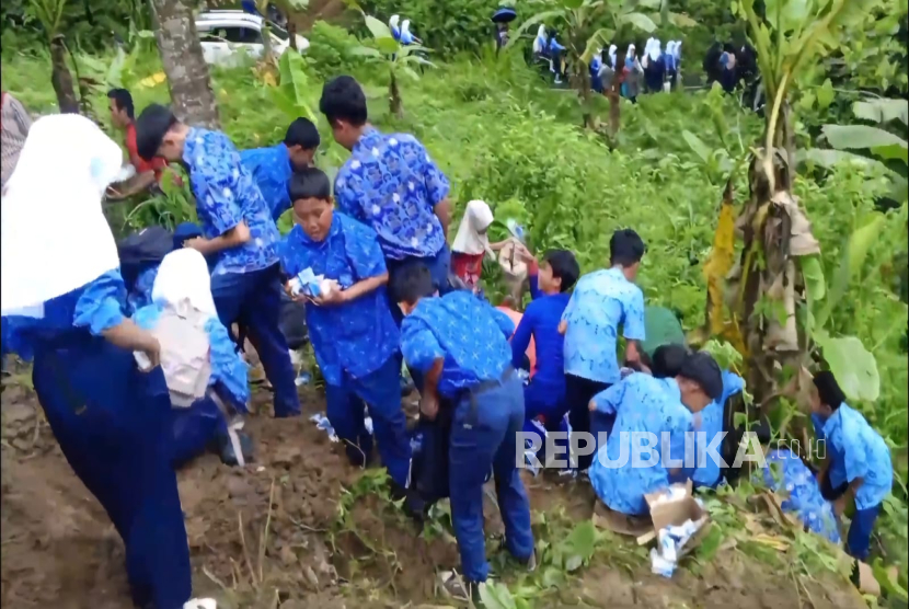 Para pelajar dipersilakan untuk berburu susu kemasan untuk program MBG yang berserakan dari truk pengangkutnya. Truk itu terperosok ke dalam jurang sedalam sepuluh meter di Jalan Raya Cipasung, Kecamatan Darma, Kabupaten Kuningan, Selasa (28/10/2025).