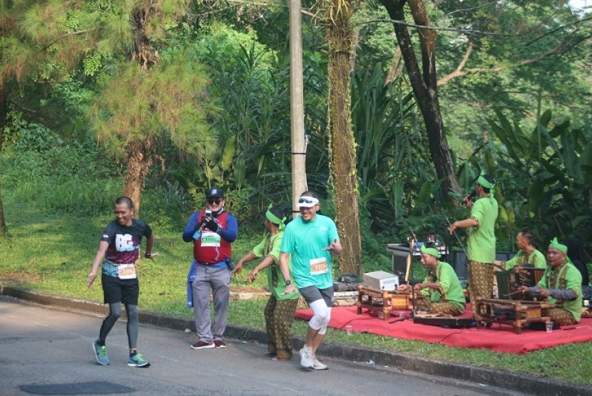 Para pelari dihibur oleh kesenian tradisional khas Sunda di area race central, Highland Marathon 2019.