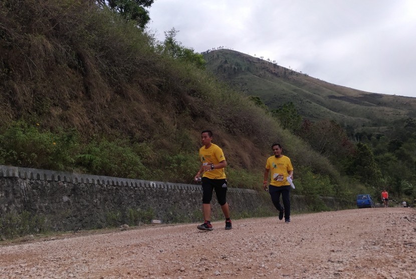 Para pelari Samosir Lake Toba Ultra Marathon sedang melintasi kawasan wisata Danau Toba, Sumatera Utara. 