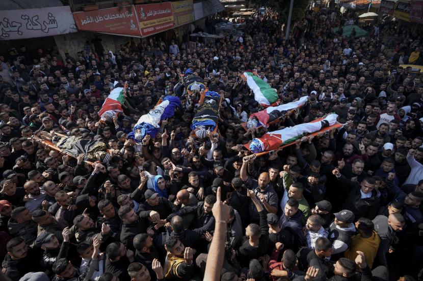 Para pelayat membawa jenazah delapan warga Palestina saat akan dilakukan pemakaman di kota Jenin, Tepi Barat.