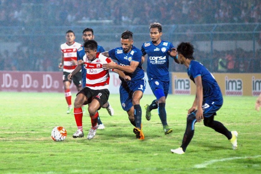 Para pemain Arema Cronus (biru) saat meladeni Madura United.