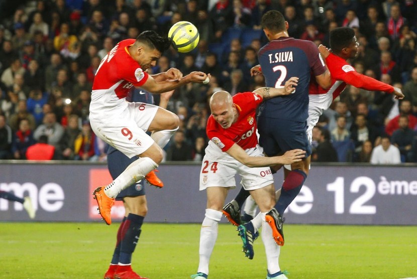 Para pemain AS Monaco (baju putih merah) jatuh bangun mengadang serangan Paris Saint-Germain.