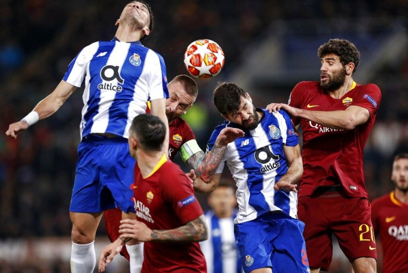 Para pemain AS Roma (merah) berduel bola dengan penggawa Porto.