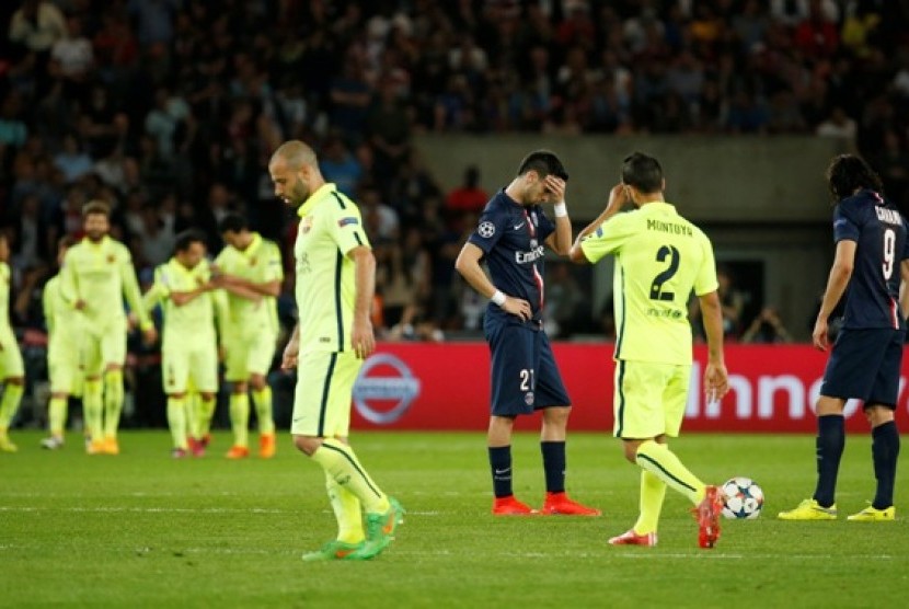 Para pemain Barcelona (kuning) merayakan gol sementara dua pemain Paris Saint-Germain tertunduk lesu.