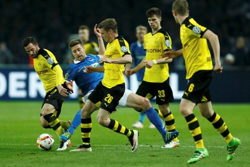 Para pemain Borussia Dortmund menghentikan pergerakan pemain Werder Bremen Jens Hegeler