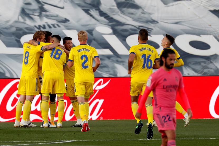 Para pemain Cadiz berkumpul merayakan gol yang mereka buat ke gawamg Real Madrid pada laga lanjutan La Liga Spanyol 2020/2021, di Stadion Alfredo Di Stefano, Madrid, Ahad (18/10). 