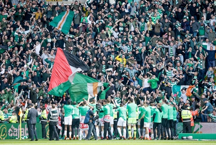 Para pemain Celtic merayakan gelar juara Liga Skotlandia bersama fan mereka di Celtic Park, Ahad (29/4).