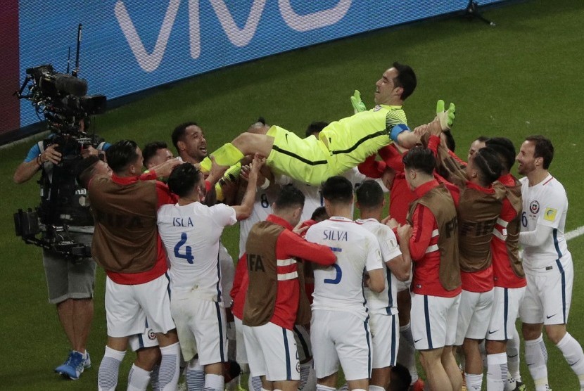 Para pemain Cile melemparkan Claudio Bravo ke atas setelah menjadi pahlawan kemenangan Cile atas Portugal pada semifinal Piala Konfederasi 2017.