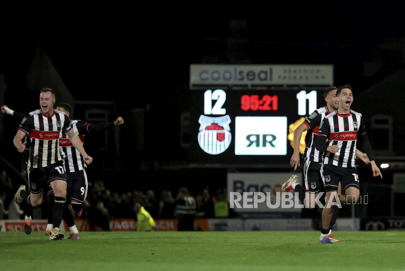 Para pemain Grimsby Town merayakan kemenangan atas Manchester United dalam adu penalti untuk memenangkan pertandingan putaran kedua Piala Liga Inggris, Kamis, 28 Agustus 2025 dini hari WIB, di Hill Blundell Park di Grimsby.