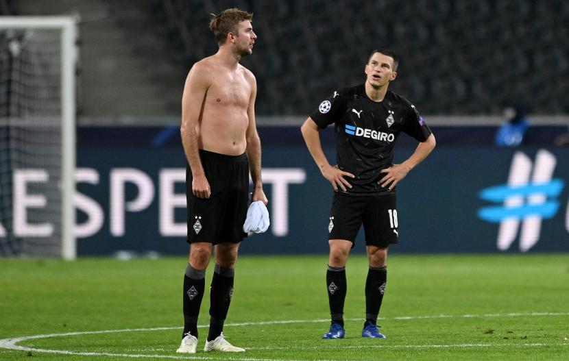 Para pemain Moenchengladbach, Christoph Kramer (kiri) dan Stefan Lainer, menunjukkan ekspresi kecewa setelah timnya menghadapai Real Madrid pada laga lanjutan penyisihan Grup B Liga Champions 2020/2021 di Borussia-Park, Jerman, Rabu (28/10).