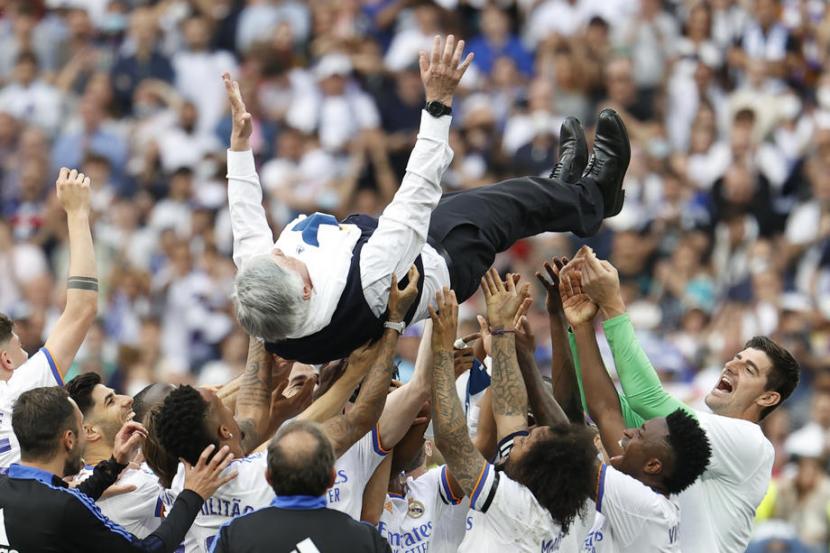 Para pemain Real Madrid mengangkat pelatih mereka Carlo Ancelotti dan melemparkanya ke atas dalam selebrasi gelar juara La Liga ke-35 Los Blancos selepas mengalahkan Espanyol 4-0 di Santiago Bernabeu, Sabtu (30/4/2022).