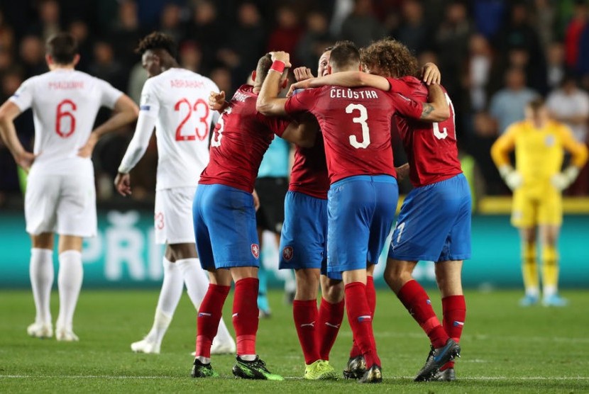 Para pemain Republik Ceska (merah) merayakan kemenangan atas Inggris pada laga kualifikasi Euro 2020. Sementara para pemain Inggris berjalan gontai usai menelan kekalahan pertama.
