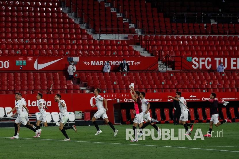 Para pemain Sevilla melakukan selebrasi usai pertandingan sepak bola La Liga Spanyol di Seville, Spanyol, Kamis (11/6).