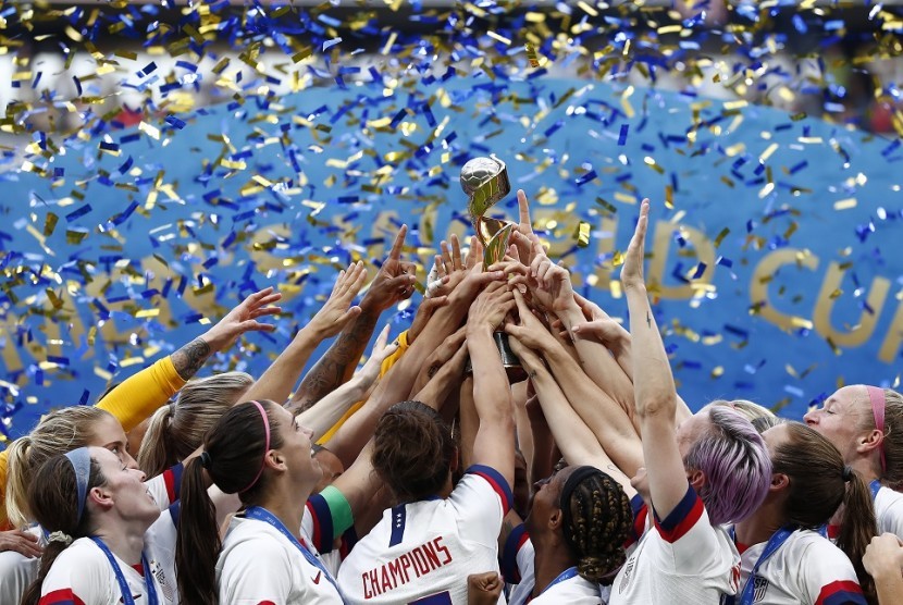 Para pemain tim sepak bola wanita Amerika Serikat mengangkat trofi juara Piala Dunia Wanita 2019.