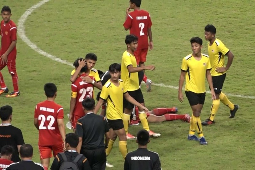 Para pemain timnas pelajar Indonesia (baju merah) dihibur pemain Malaysia usai kalah pada semifinal Kejuaraan Sepak Bola Pelajar Asia 2019.
