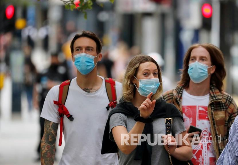  Para pembeli yang mengenakan masker berjalan di sepanjang Oxford Street di London, Selasa, 14 Juli 2020.