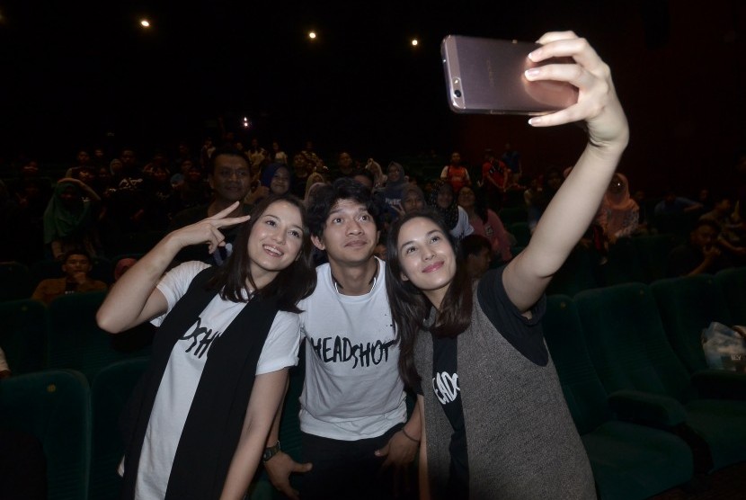 Para pemeran film Headshot, Julie Estelle (kiri), Iko Uwais (tengah), Chelsea Islan (kanan), berswafoto bersama penonton saat penayangan film tersebut di Cinema XXI Panakukkang, Makassar, Sulawesi Selatan, Minggu (20/11). 