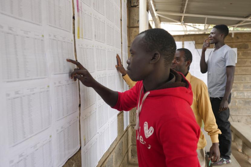 Para pemilih memeriksa nama mereka di tempat pemungutan suara di Nairobi, Senin 8 Agustus 2022. Warga Kenya memberikan suara pada Selasa untuk memilih pengganti Presiden Uhuru Kenyatta setelah satu dekade berkuasa. Perlombaan sudah dekat dan bisa melaju ke putaran kedua untuk pertama kalinya.