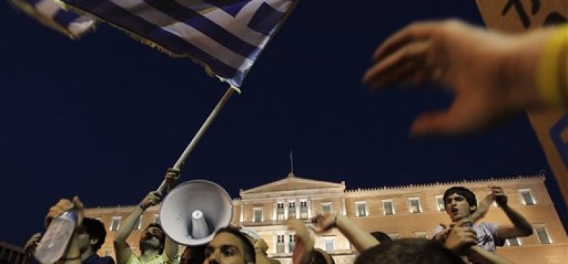 Para pemrotes berunjuk rasa di depan parlemen Yunani terkait dengan krisis ekononomi yang melanda negara itu.