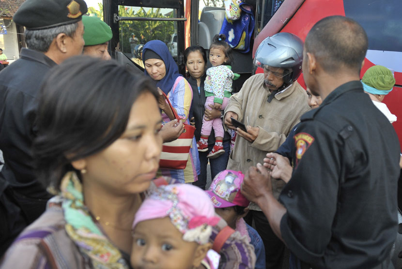 Anggota Satuan Polisi Pamong Praja memeriksa identitas pemudik saat operasi penertiban pendatang pada arus balik Idul Fitri 1435 H di Terminal Ubung, Denpasar, Sabtu (2/8). (Antara/Nyoman Budhiana)