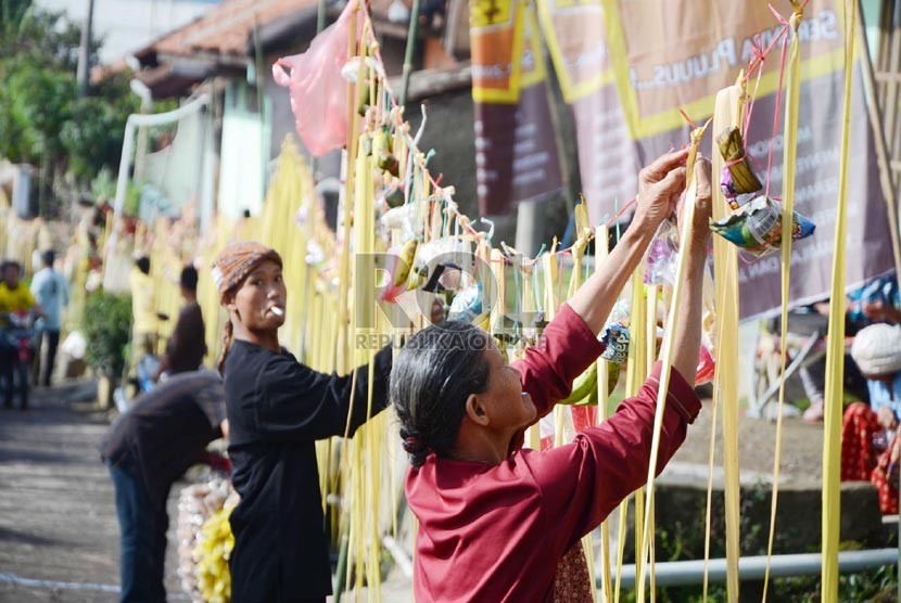  Para penduduk memasang sawen berupa makanan ringan dan hasil pertanian pada acara 'Ngaruat Bumi dan Rempug Tarung Adu Tomat ' di kampung Cikareumbi, Kabupaten Bandung Barat, Kamis (14/11). (Republika/Edi Yusuf)