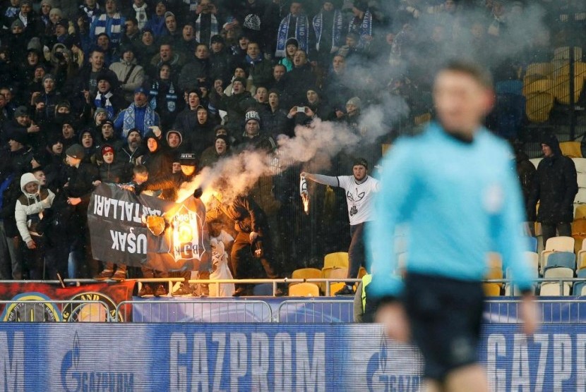 Para pendukung Dynamo Kiev membakar spanduk Besiktas di Stadion Olympiyskiy saat kedua tim berhadapan pada Rabu (7/12) dini hari WIB.