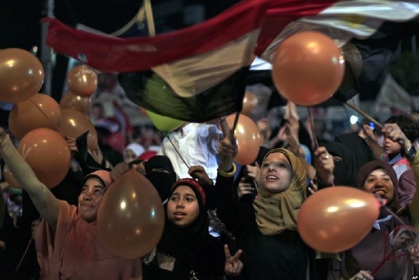Para pendukung Mursi memegang balon dan mengibarkan bendera saat merayakan Idul Fitri di Kairo 