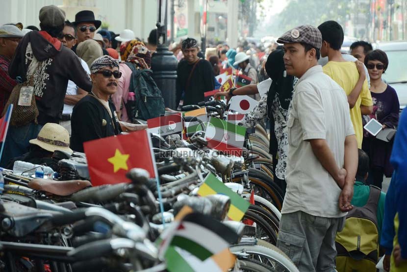 Para penggemar sepeda tua dengan memakai bendera-bendera peserta KAA memarkir sepedanya di Jl Asia Afrika, Kota Bandung, Ahad (19/4). (Edi Yusuf/Republika)